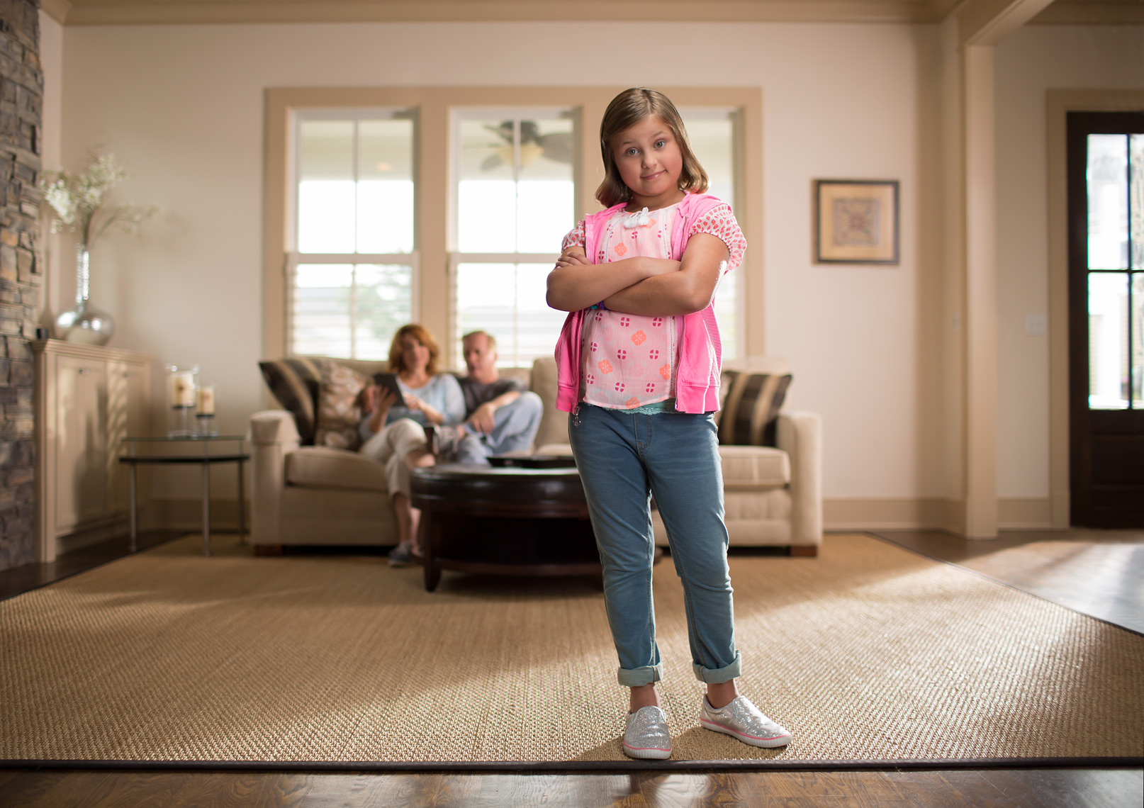 Kid in Living Room with Parents in Background